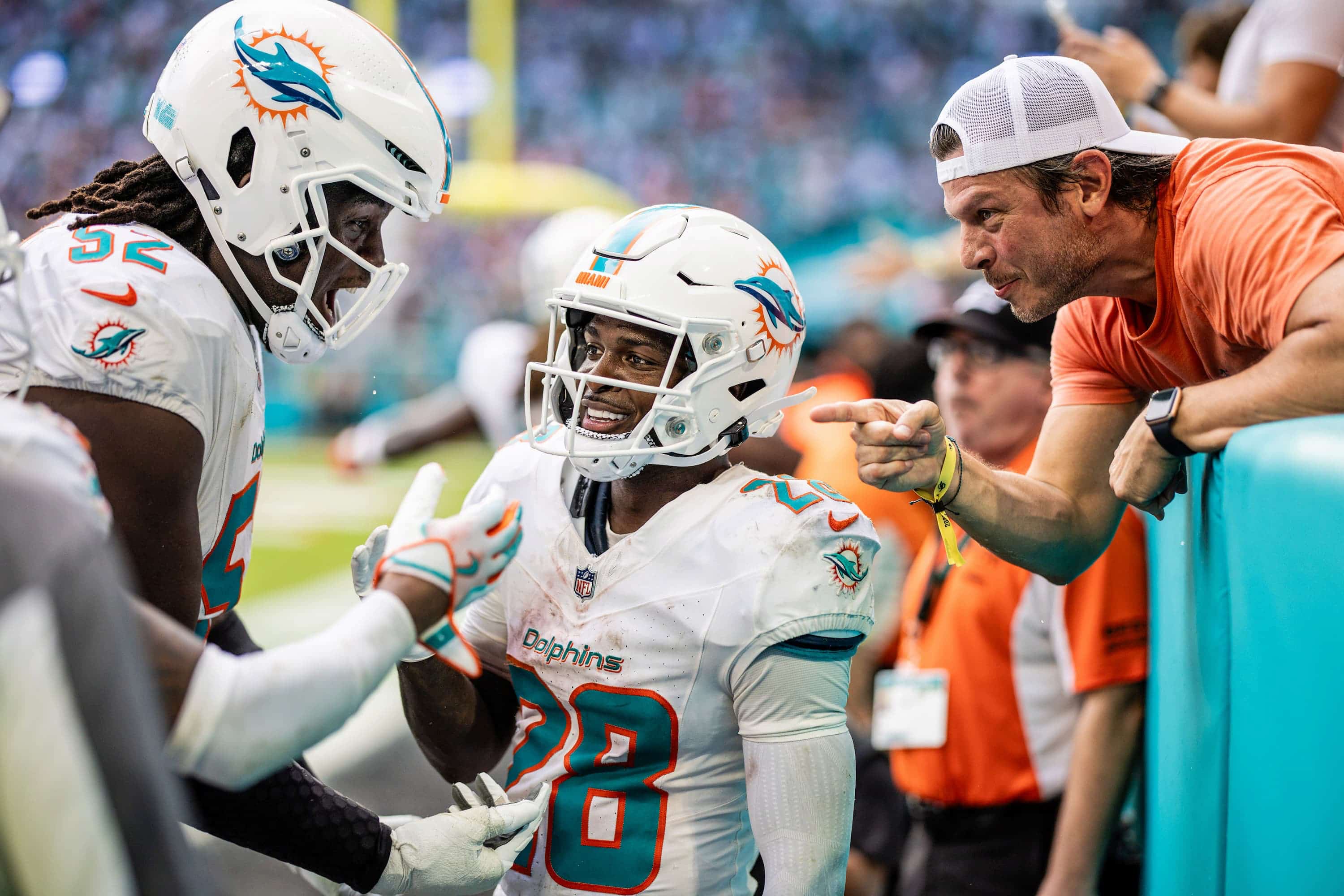 251109-BUFvsMIA-TDS325-2-2 De'Von Achane celebrates a touchdown with teammate Patrick Paul and a very excited fan.